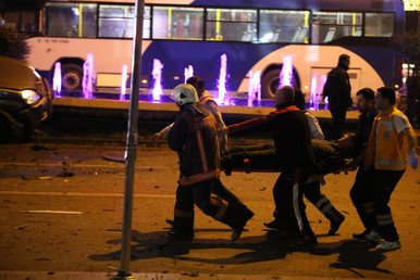 رجال من مصلحة الطوارئ يحملون شخصا جريحا على نقالة من موقع التفجير