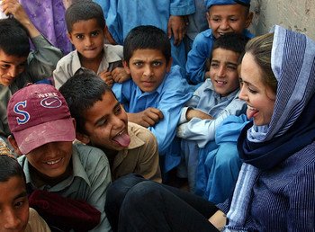 أنجلينا جولي تلعب مع أطفال اللاجئين الأفغان خلال زيارتها مخيم كاشا غاري للاجئين في بيشاور عام 2005.