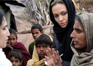 سفيرة النوايا الحسنة الممثلة أنجلينا جولي تستمع إلى الناجين من الزلزال خلال زيارتها جبل شارون في قرية نائية في الشطر الباكستاني من كشمير عام 2005.