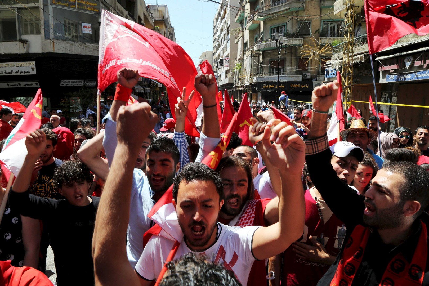 متظاهرون يحملون أعلاما حمراء في أثناء مسيرة نظمها الحزب الشيوعي اللبناني