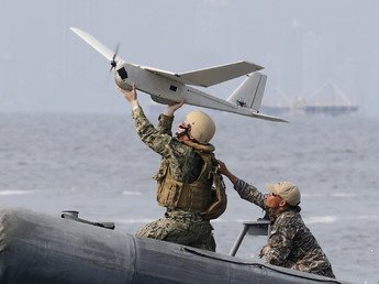 جندي من البحرية الامريكية يستعد لإطلاق طائرة من دون طيار برفقة جنود من البحرية الفلبينية على متن زورق دورية خلال المناورات العسكرية السنوية المشتركة