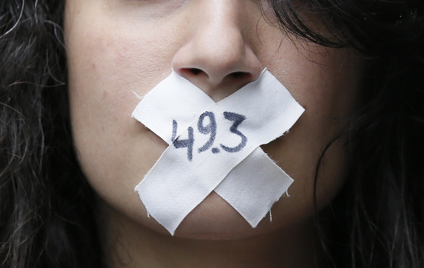 امرأة تضع لاصقا بالأرقام، "49.3" الرمزية على فمها للتعبير عن الاحتجاج ضد إصلاح قانون العمل الفرنسي في باريس