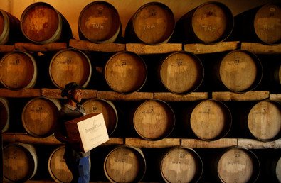 عامل يحمل صندوق من النبيذ المصنوع في مزرعة العنب جنوب إفريقيا