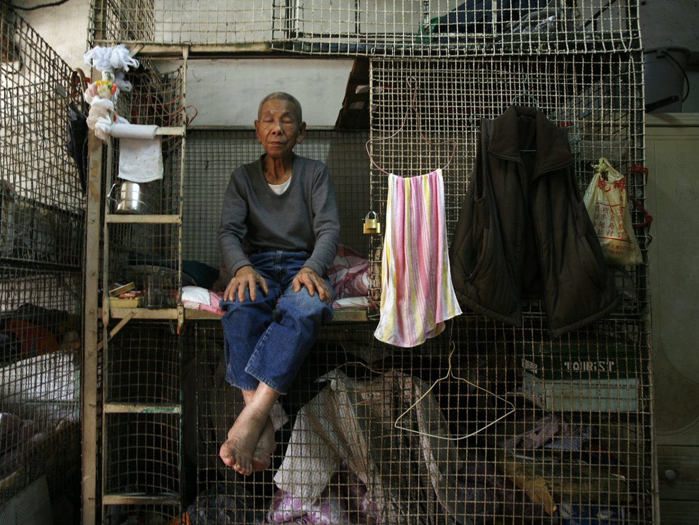 مئات من كبار السن يعيشون في أقفاص في قاعة تتضمن 12 قفصا، هونغ كونغ