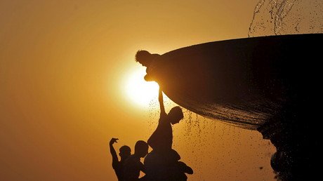 أولاد يبتردون تحت نافورة ماء