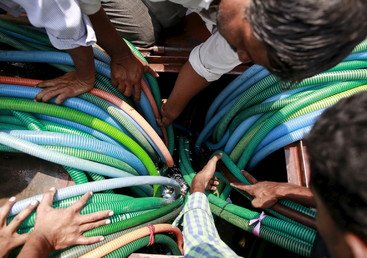 سكان محليون يدسّون الخراطيم البلاستيكية لسحب الماء من صهريج حكومي