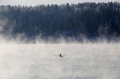 رجل يجذف في قاربه في الضباب على نهر ينيسي