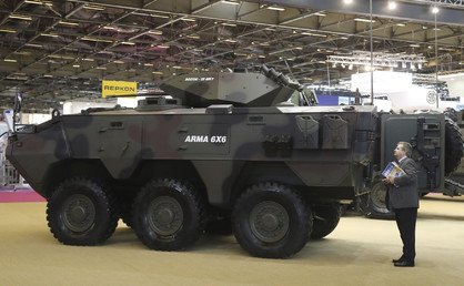 أحد الزوار ينظر إلى آلية عسكرية ذات دفع سداسي