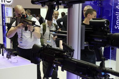 رجل يجرب سلاحا معروضا في جناح للأسلحة الخفيفة