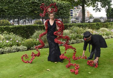 عارضة الأزياء أنيكا سفينسكا في أثناء تصحيح وضعية قبعتها قبل بداية السباق