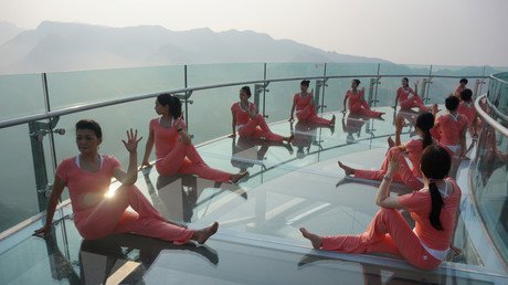 أشخاص يمارسون رياضة اليوغا على منصة من الزجاج عشية يوم اليوغا العالمي