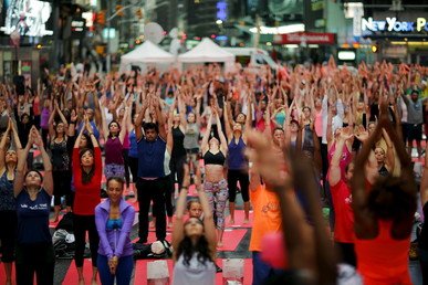 أشخاص يمارسون رياضة اليوغا في تايمز سكوير في نيويورك في يوم اليوغا العالمي