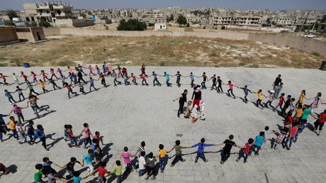 طلاب مدرسة يشكلون دائرة في أثناء احتفالهم بنهاية العام الدراسي