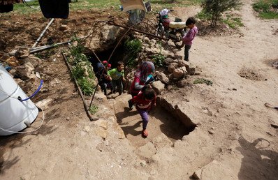 أطفال مشردون يصعدون درجاً يؤدي إلى كهف بعد حضورهم الدرس فيه