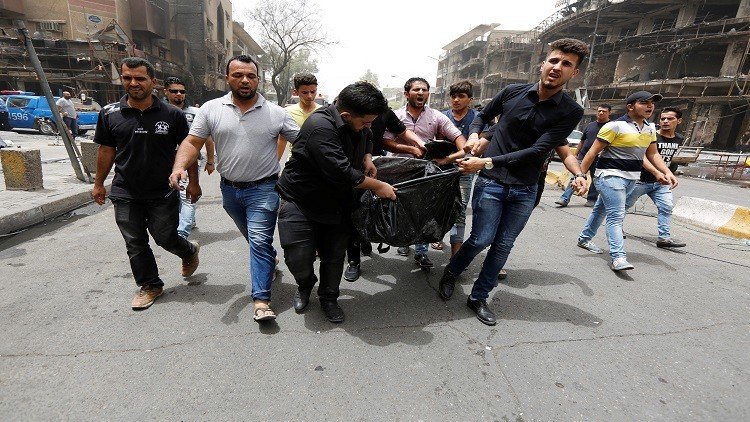 عراقيون ينقلون ضحايا التفجير إلى سيارات الإسعاف 
