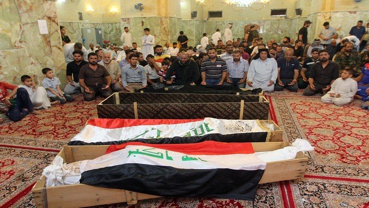 أهالي الضحايا يؤدون الصلاة بالقرب من التوابيت 