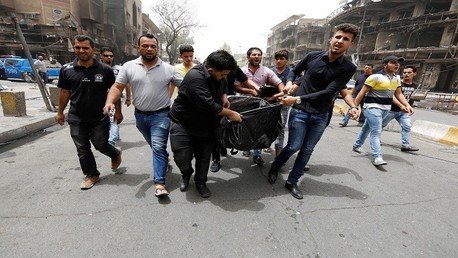 عراقيون ينقلون ضحايا التفجير إلى سيارات الإسعاف 
