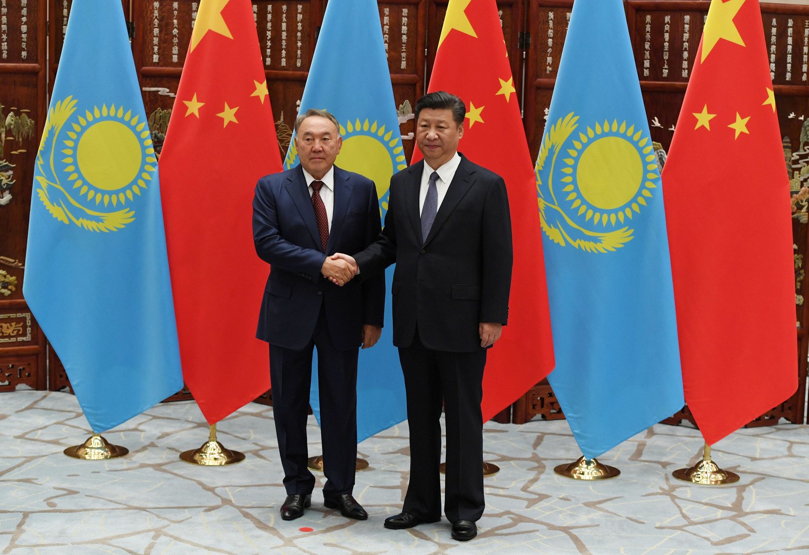 الرئيس الصيني شي جين بينغ يصافح رئيس كازاخستان  نور سلطان نزارباييف