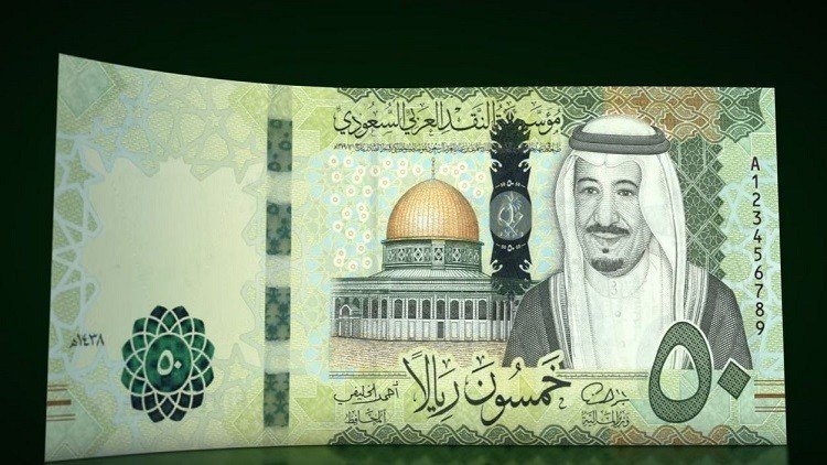 الملك سلمان يتسلم الرقم الأول من العملة الجديدة (صور)