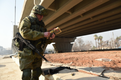 جندي روسي يفكك عبوة ناسفة تحت أحد الجسور في حلب 