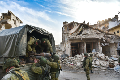 جنود روس يقومون بجمع القذائف الصاروخية التي خلفها المسلحون شرق حلب