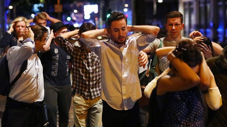 People leave the area with their hands up after an incident near London Bridge in London