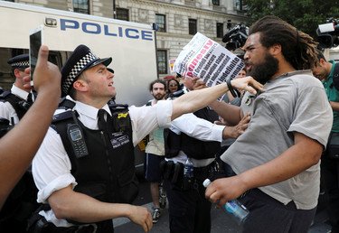 أحد رجال الشرطة في مواجهة مع متظاهر خلال مظاهرة في ساحة البرلمان في لندن
