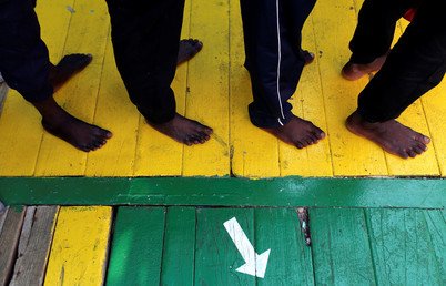 مهاجرون ينتظرون النزول من سفينة فوس هيستيا عند وصولهم إلى ميناء كروتوني بإيطاليا، بعد أن أنقذهم طاقم منظمة "أنقذوا الأطفال" في البحر الأبيض المتوسط قبالة ساحل ليبيا
