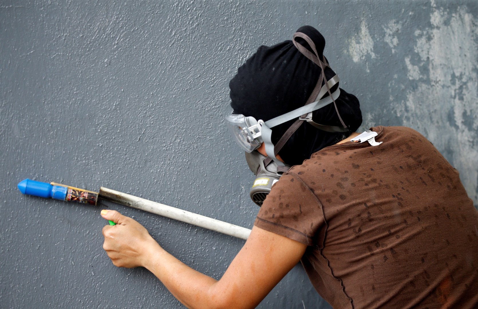 متظاهر يحاول إشعال الألعاب النارية خلال الاشتباكات مع قوات الأمن في فالنسيا، بفنزويلا. 6 أغسطس 2017