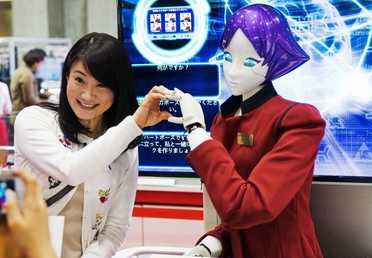 زائرة تتصور مع رجل آلي "FASHION Junko Koshino" في المعرض الدولي للروبوتات "IREX " في طوكيو