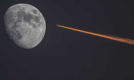 القمر والطائرة على خلفية غروب الشمس