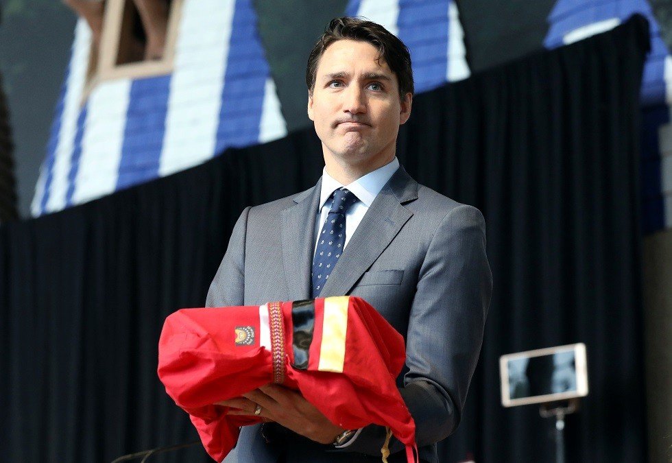 رئيس الوزراء الكندي جاستن ترودو حاملا تقرير الإبادة الجماعية