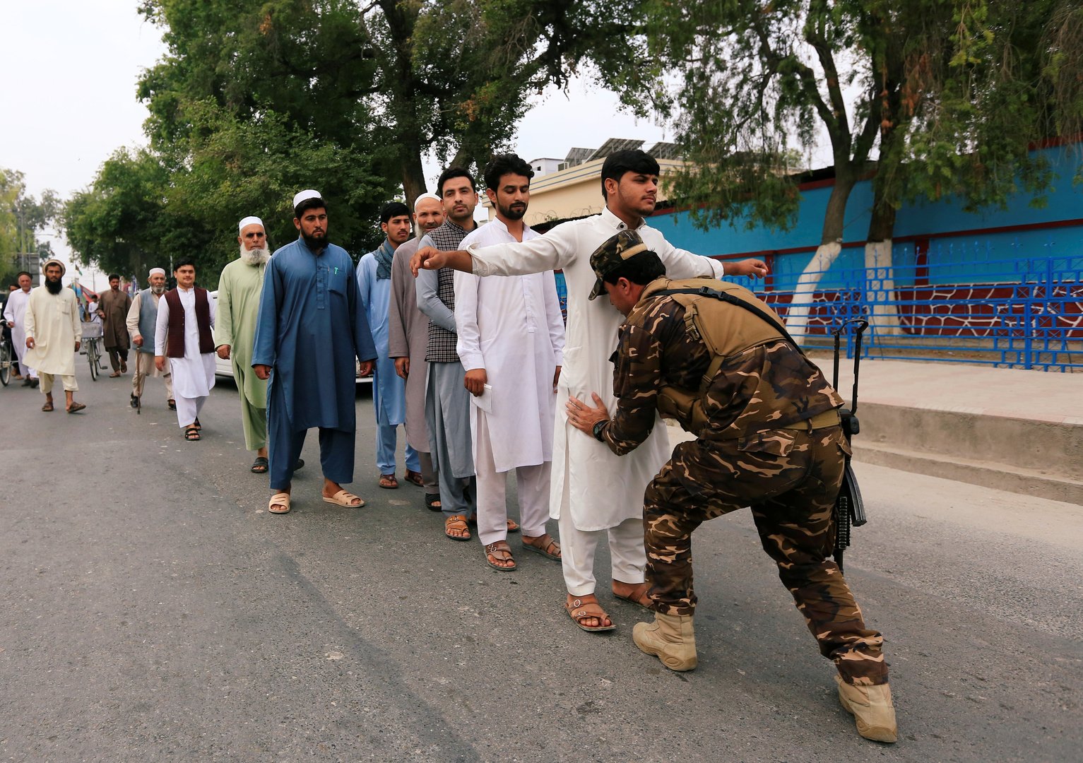 عنصر من الأمن الأفغاني يفتش الناخبين الراغبين في الإدلاء بأصواتهم في انتخابات الرئاسة 2019 في مدينة جلال آباد