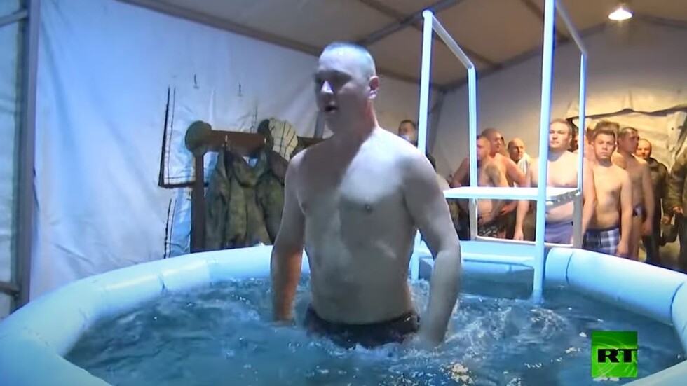 جنود روس يؤدون طقس الغطاس في ظروف ميدانية بقاعدة حميميم