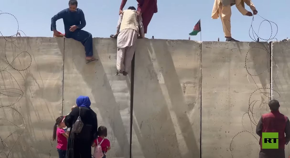 الأفغان يتسلقون جدارا للوصول إلى مدرج مطار حامد كرزاي الدولي