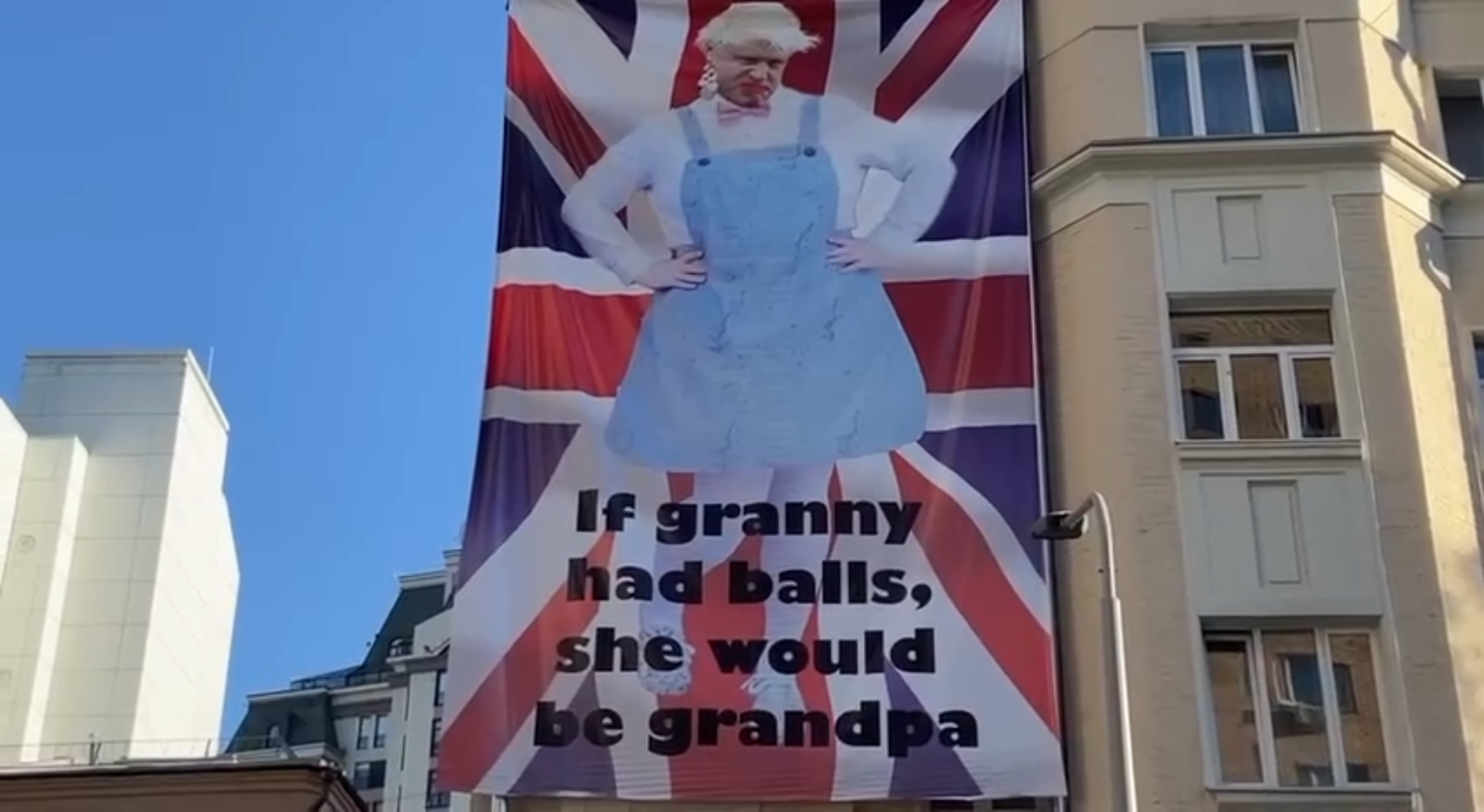ردا على كلمات جونسون حول بوتين.. لافتة تحمل صورة رئيس الوزراء البريطاني بملابس نسائية في موسكو
