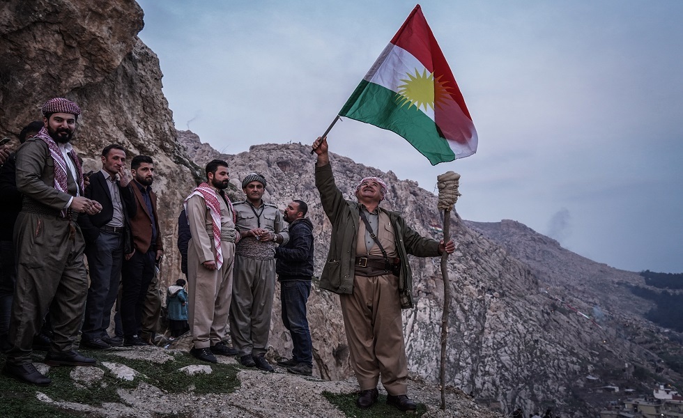العراق - رجل كردي يرفع علم الدولة الكردية في يوم رأس السنة الكردية 