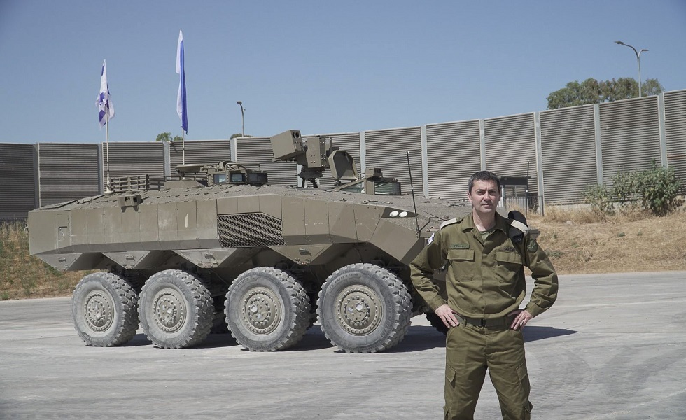 جندي إسرائيلي يقف بالقرب من عربة مدرعة