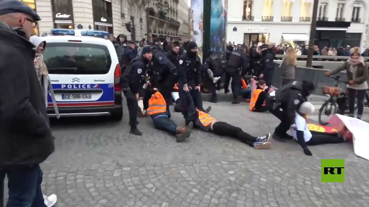 شاهد.. عناصر الشرطة الفرنسية يبعدون نشطاء البيئة الذين أغلقوا طريق الشانزليزيه