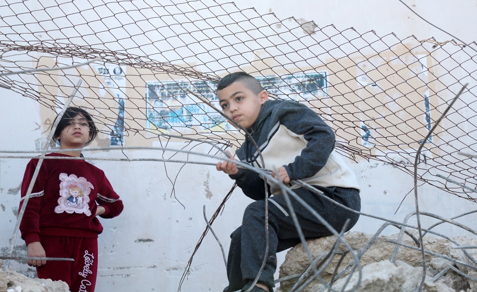 أطفال من مخيم جنين أمام أنقاض بيت دمره الجيش الإسرائيلي