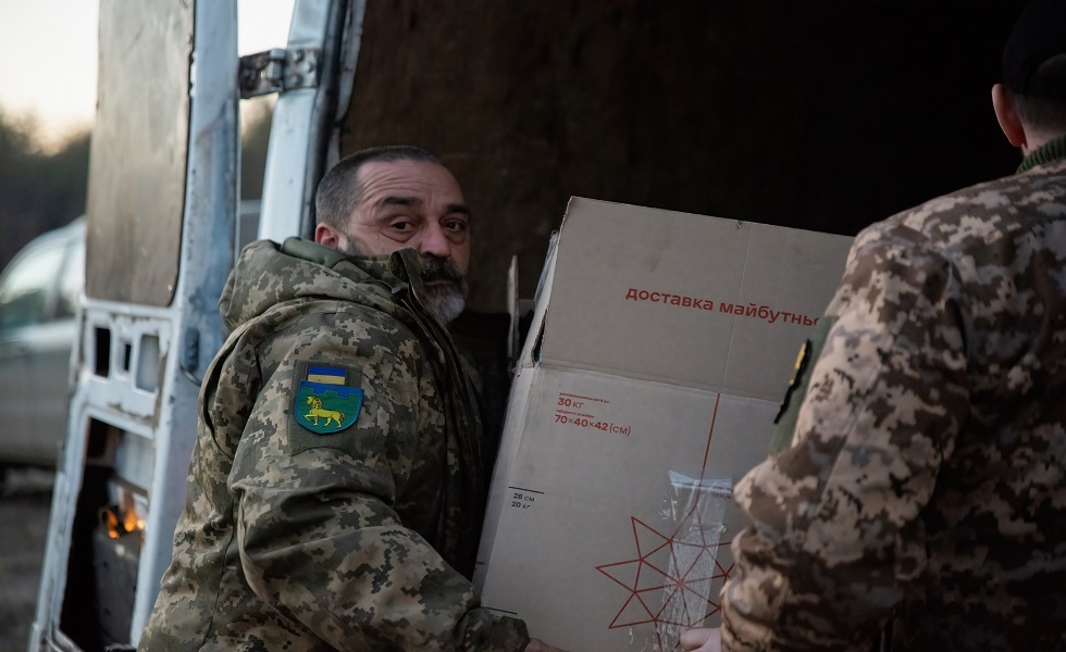 جنود أوكرانيون يحملون بعض المساعدات المقدمة لهم