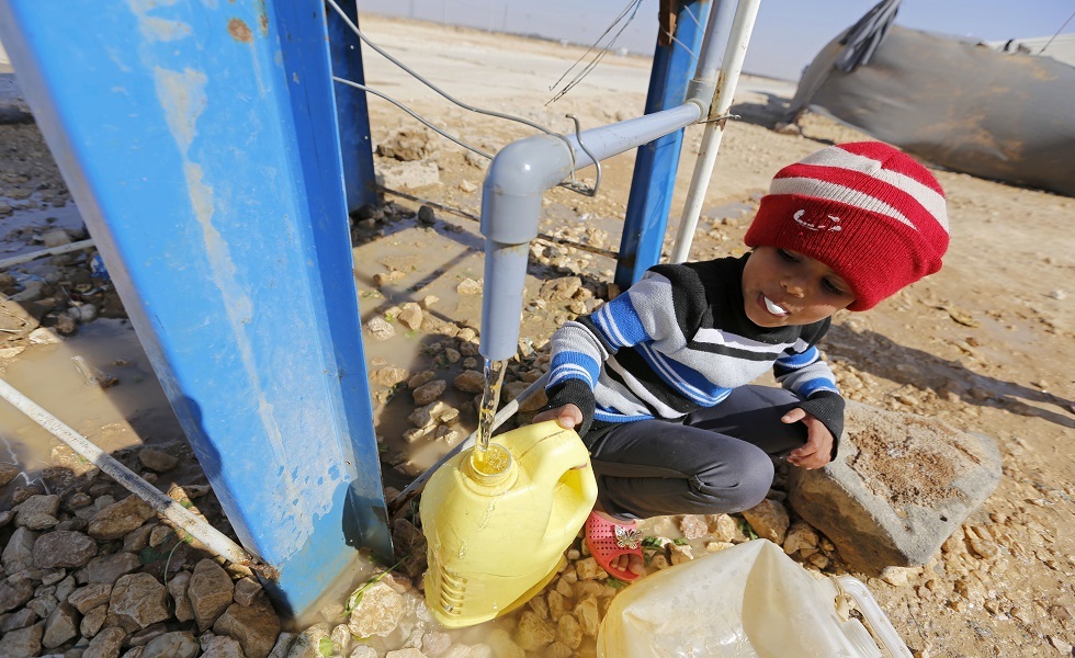 طفل لاجئ ينهل من الماء للشرب في مخيم الزعتري - الأردن