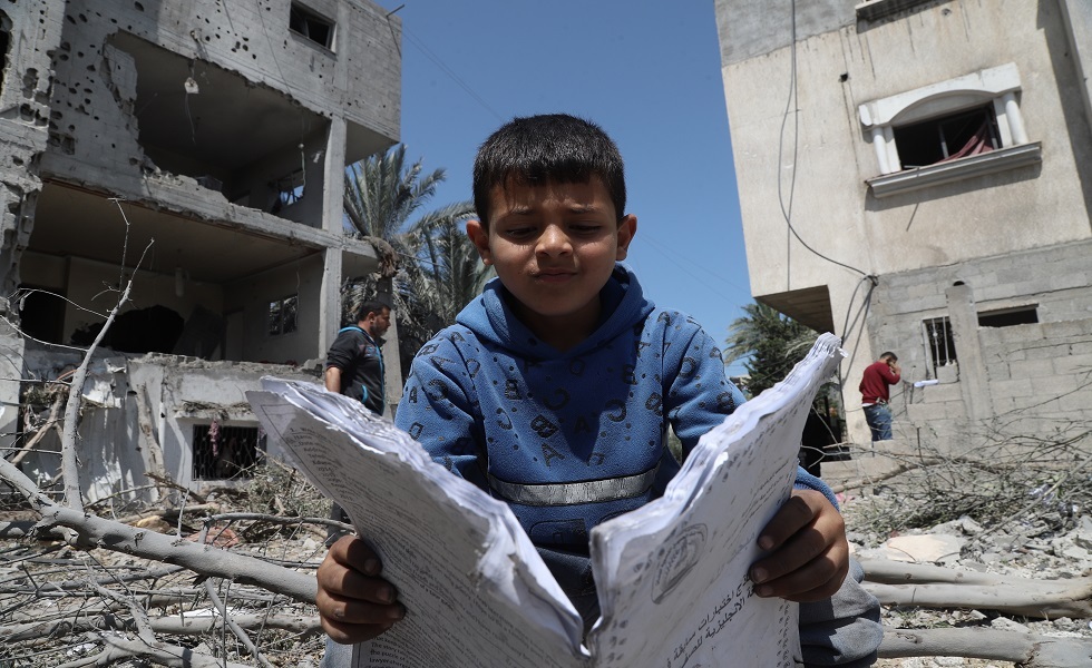 طفل فلسطيني يتفقد حطام منزله ذويه بعد غارة جوية إسرائيلية على دير البلح وسط قطاع غزة.