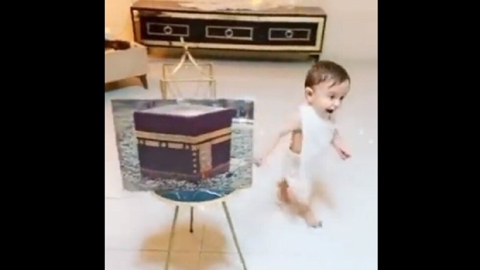 طفل يطوف حول صورة الكعبة (فيديو)