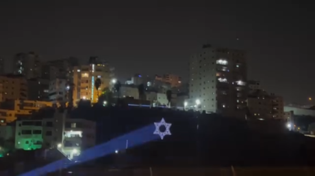 مستوطنون يستفزون الفلسطينيين بمخيم شعفاط في القدس بتوجيه أضواء ترسم علم إسرائيل على المباني (فيديو)