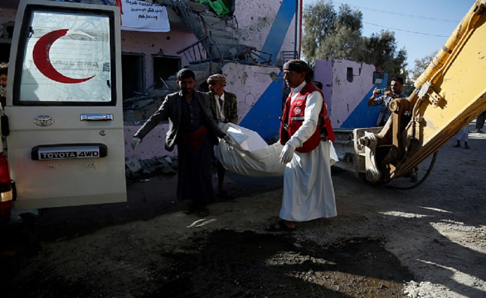 أفراد الإنقاذ يحملون جثة قُتلت في غارات جوية لطائرات التحالف العربي واستهدفت سجنا في صعدة - اليمن
