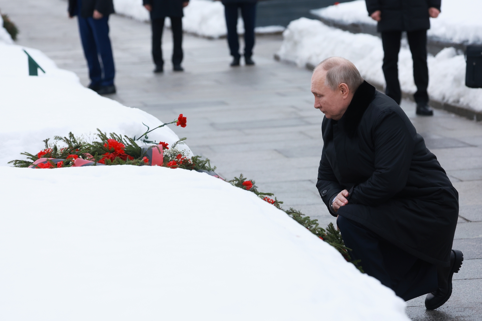 بوتين يجثو على ركبته ويضع الزهور على ضريح جماعي يضم جثمان أخيه (فيديو + صورة)