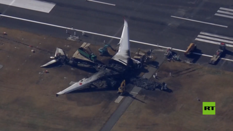 شاهد.. عملية تفكيك طائرة يابانية محترقة في مطار طوكيو
