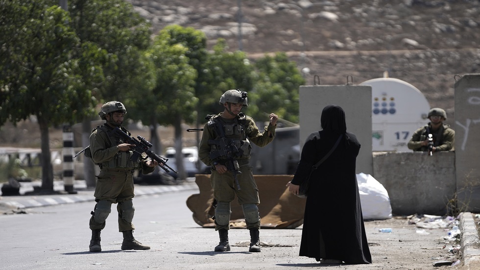 جنود إسرائيليون يحققون مع امرأة  فلسطينية بالقرب من مستوطنة بيت حجاي جنوب مدينة الخليل