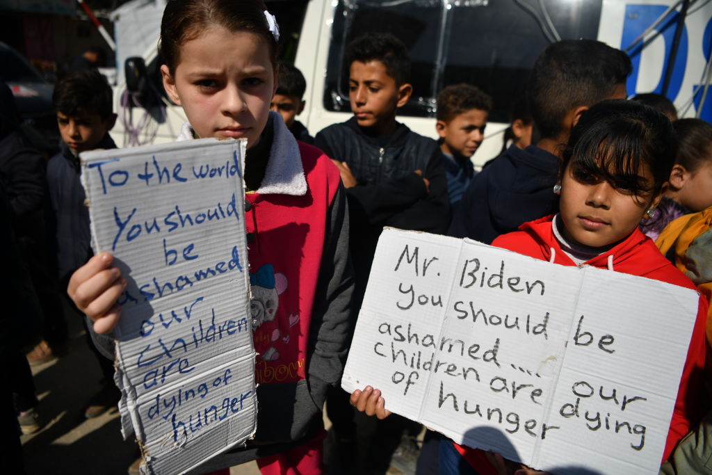 أطفال فلسطينيون لاجئون في رفح يتظاهرون دعما لأقرانهم الذين يعانون من نقص الغذاء في شمال القطاع، 21 فبراير 2024.